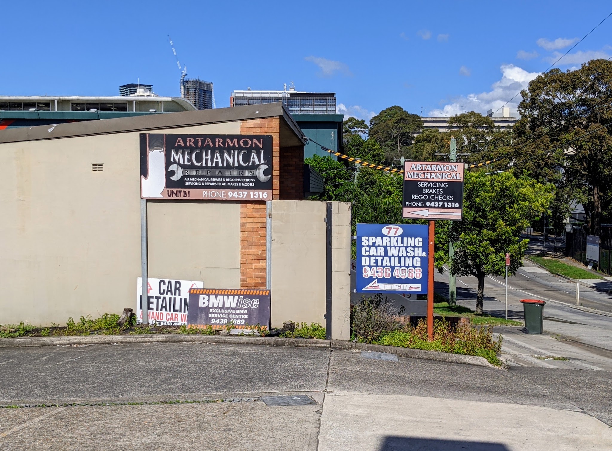 The Artarmon Mechanical Repairs pole sign on Reserve Rd against the Sydney skyline